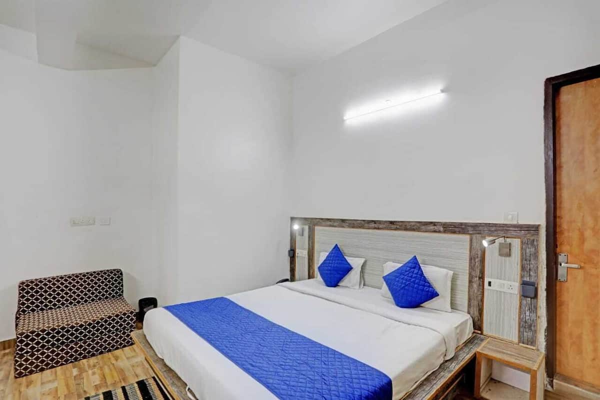 A bedroom with a bed, a chair, and a wooden door.