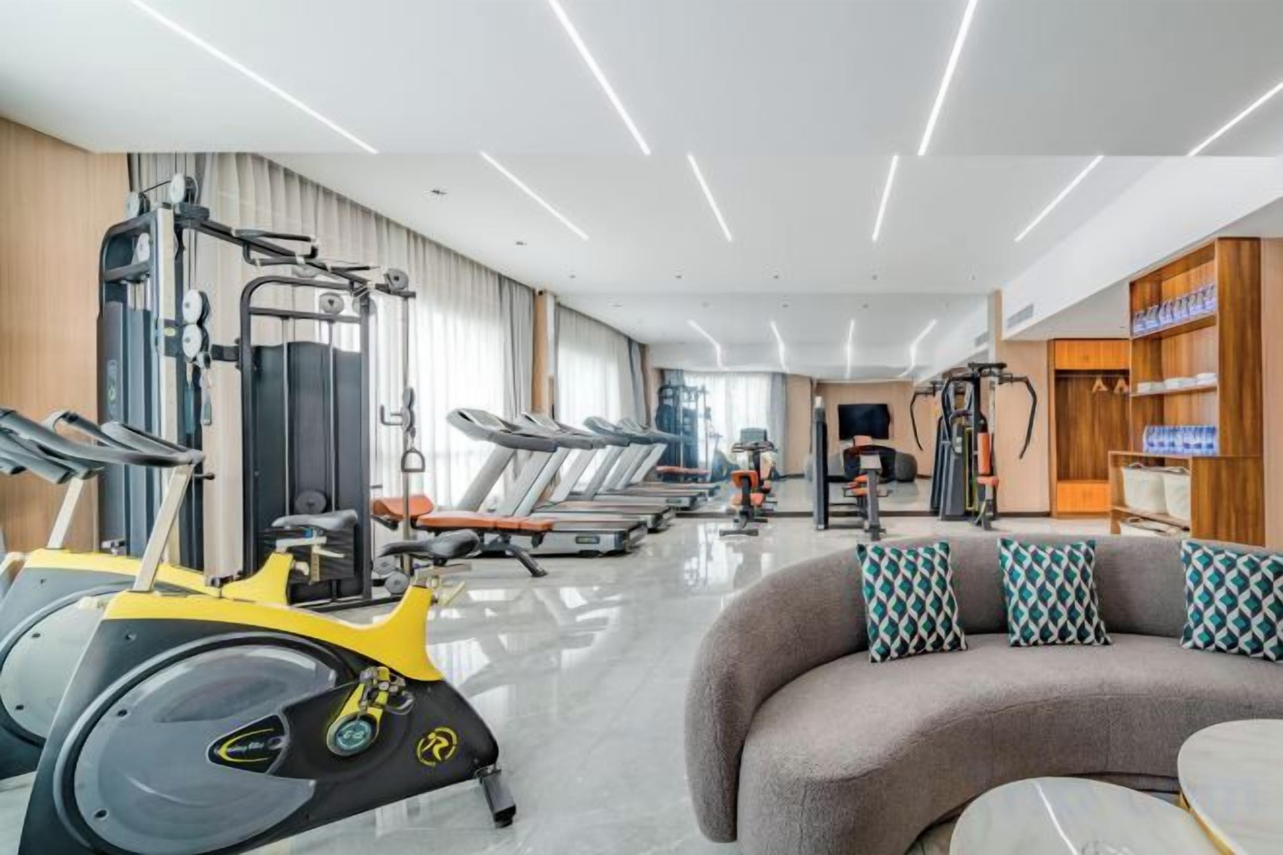 A gym with treadmills, elliptical machines, and weightlifting equipment.
