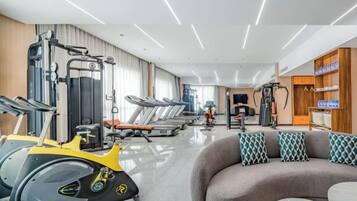 A gym with treadmills, elliptical machines, and weightlifting equipment.