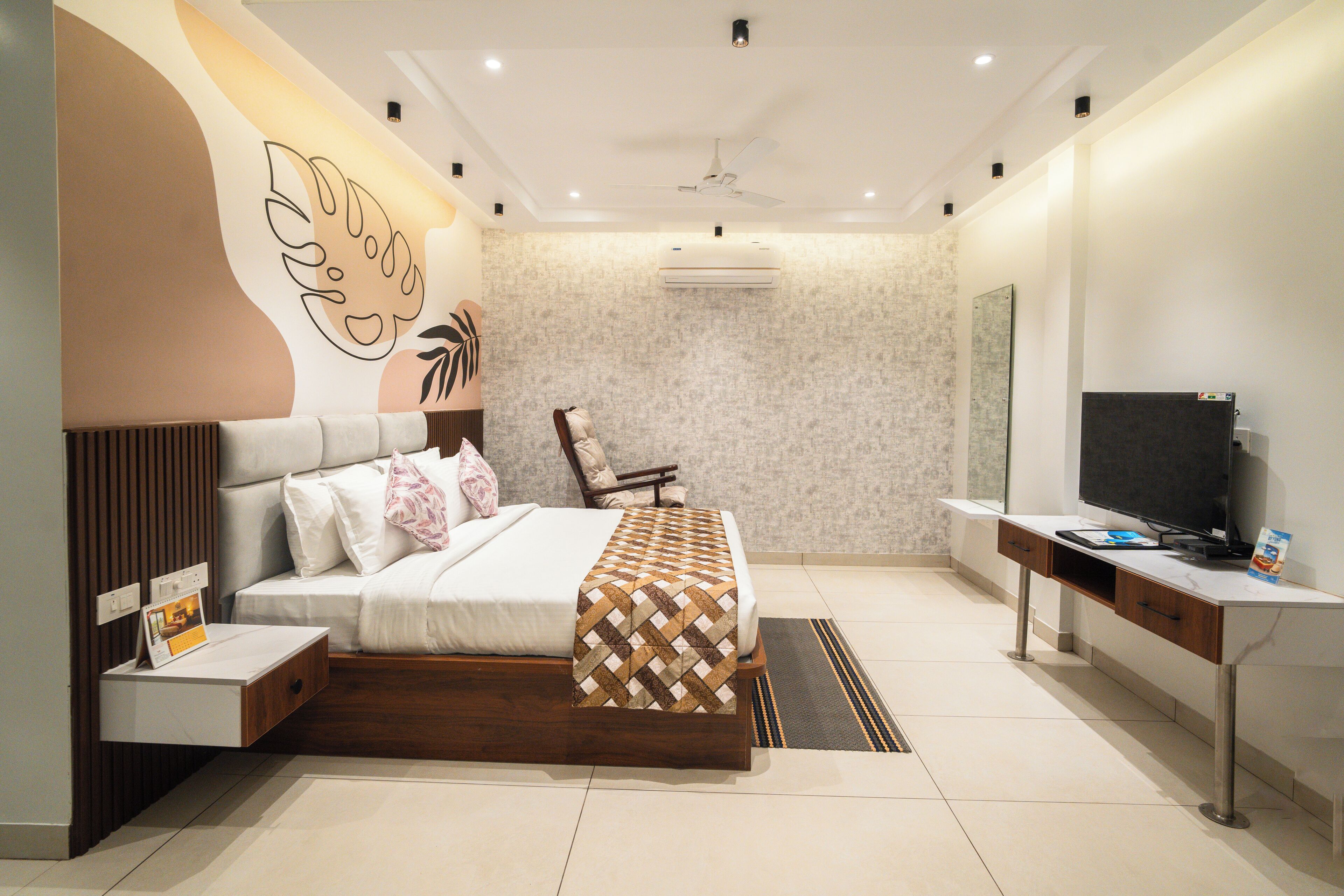 A modern bedroom with a bed, bedside table, TV, and a desk.