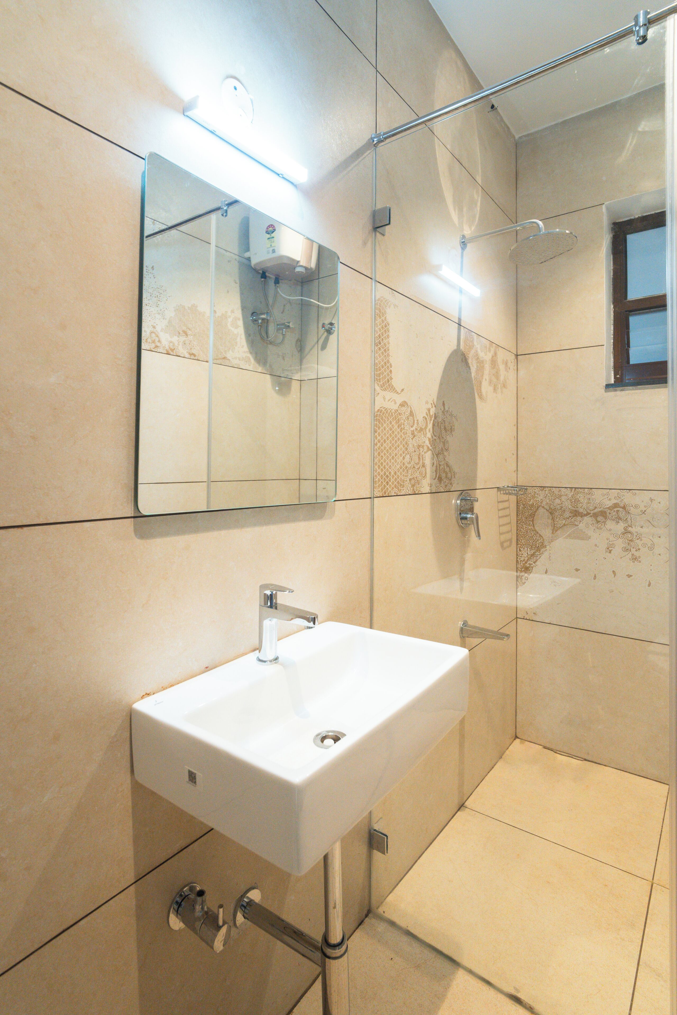 Un baño con lavamanos blanco, espejo y ducha.