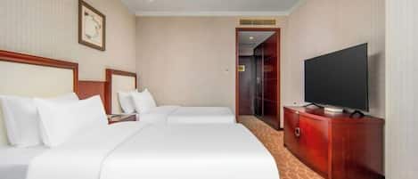 Una habitación de hotel con dos camas, un televisor y un armario de madera.