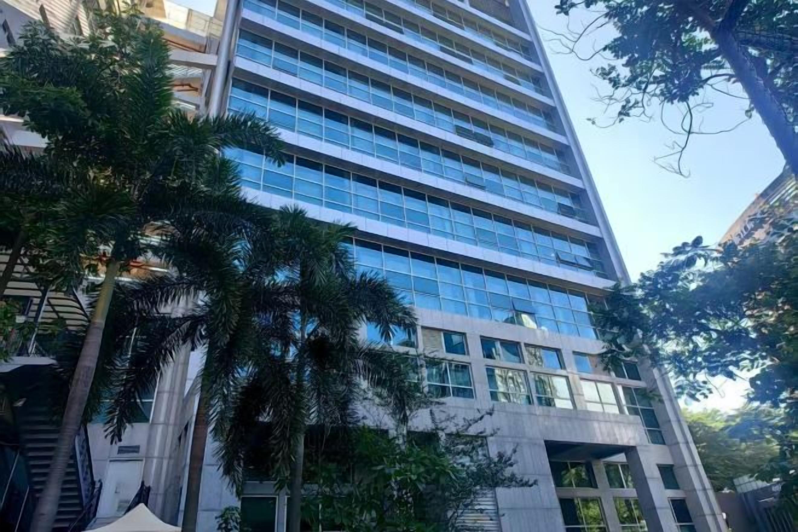 A multi-story building with a modern architectural design, featuring a glass facade and a series of balconies.