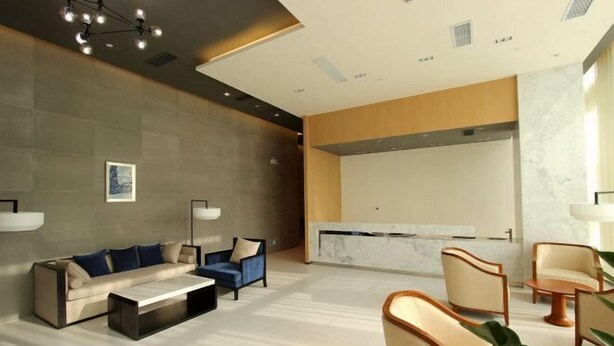 A modern lobby with a sofa, armchairs, a coffee table, and a reception desk. - Jinjiang Inn (Shenzhen Nanshan Science & Technology Park) (Shenzhen)