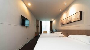 A hotel room with a large bed, a flat-screen TV mounted on the wall, and a framed picture above the bed. - Jinjiang Inn (Shenzhen Nanshan Science & Technology Park) (Shenzhen)