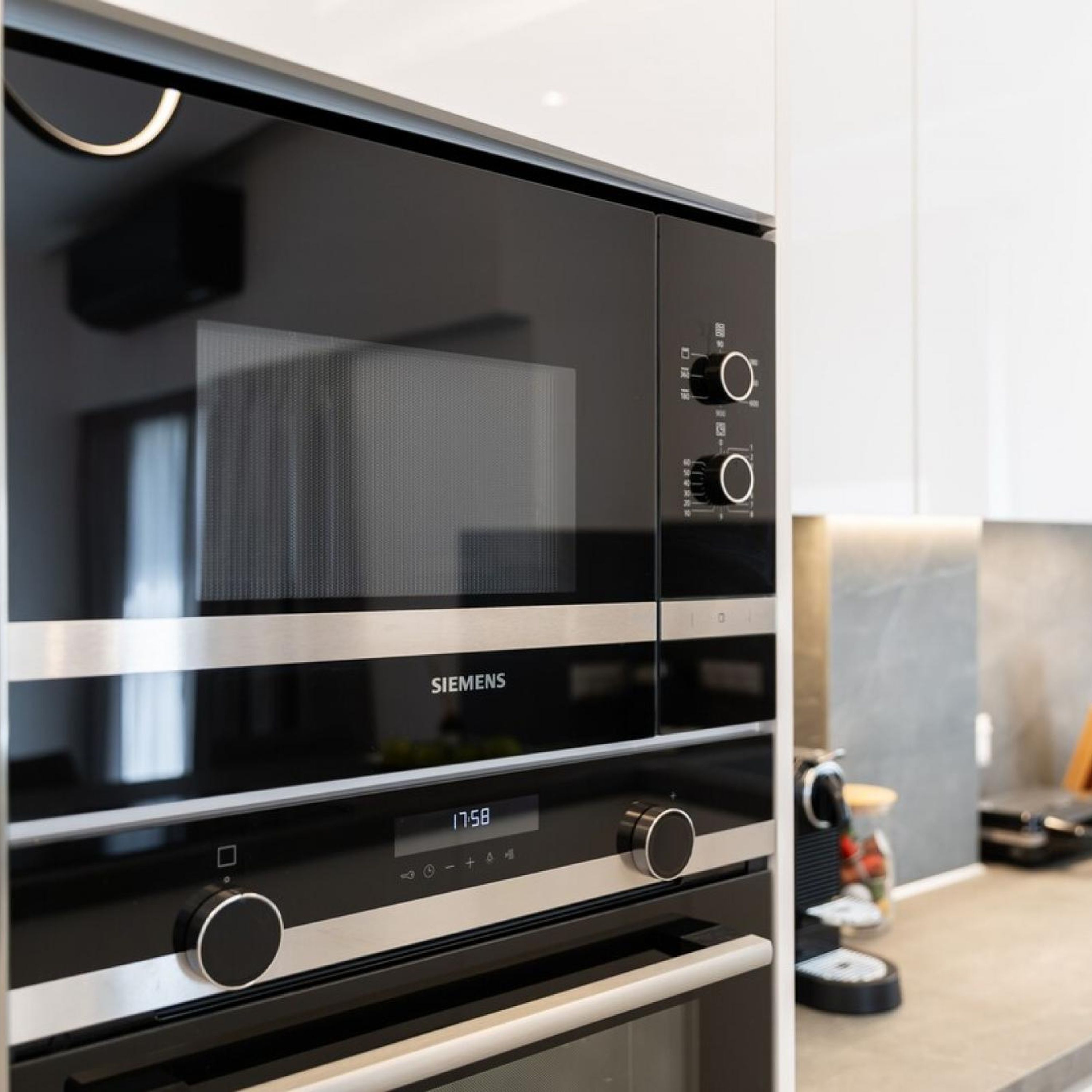 A Siemens microwave oven with a digital display, control knobs, and a stainless steel finish.