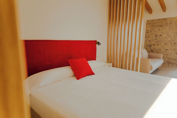 A bed with a red headboard, white bedding, and a red pillow. - Finca Son Oms (Porreres)