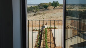 Ein Balkon mit Blick auf eine trockene Landschaft und ferne Hügel.