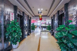 A corridor with potted plants, a ceiling with a disco ball, and a storefront with a sign. - Mujinhua Hotel (Chongqing)