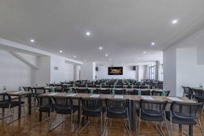 A conference room with multiple tables and chairs, a flat-screen TV, and a large window. - Mujinhua Hotel (Chongqing)