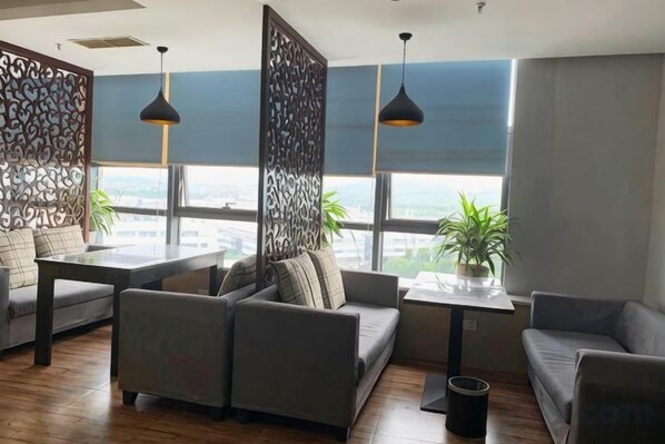 A modern lounge area with sofas, a table, and pendant lighting. - Mujinhua Hotel (Chongqing)