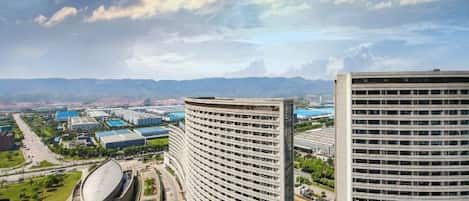 A high-rise building with a curved facade, surrounded by other buildings and a clear sky.