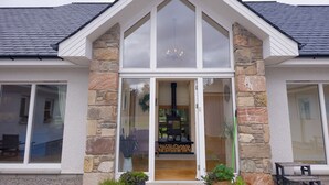 Ein Haus mit Steinaußenwand, großen Fenstern und modernem Design.