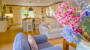 Ein geräumiges Wohnzimmer mit einem blauen Sofa und einer dekorativen Blumenvase.