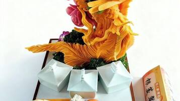Un ramo de flores, una caja de regalo y una tarjeta sobre una mesa.