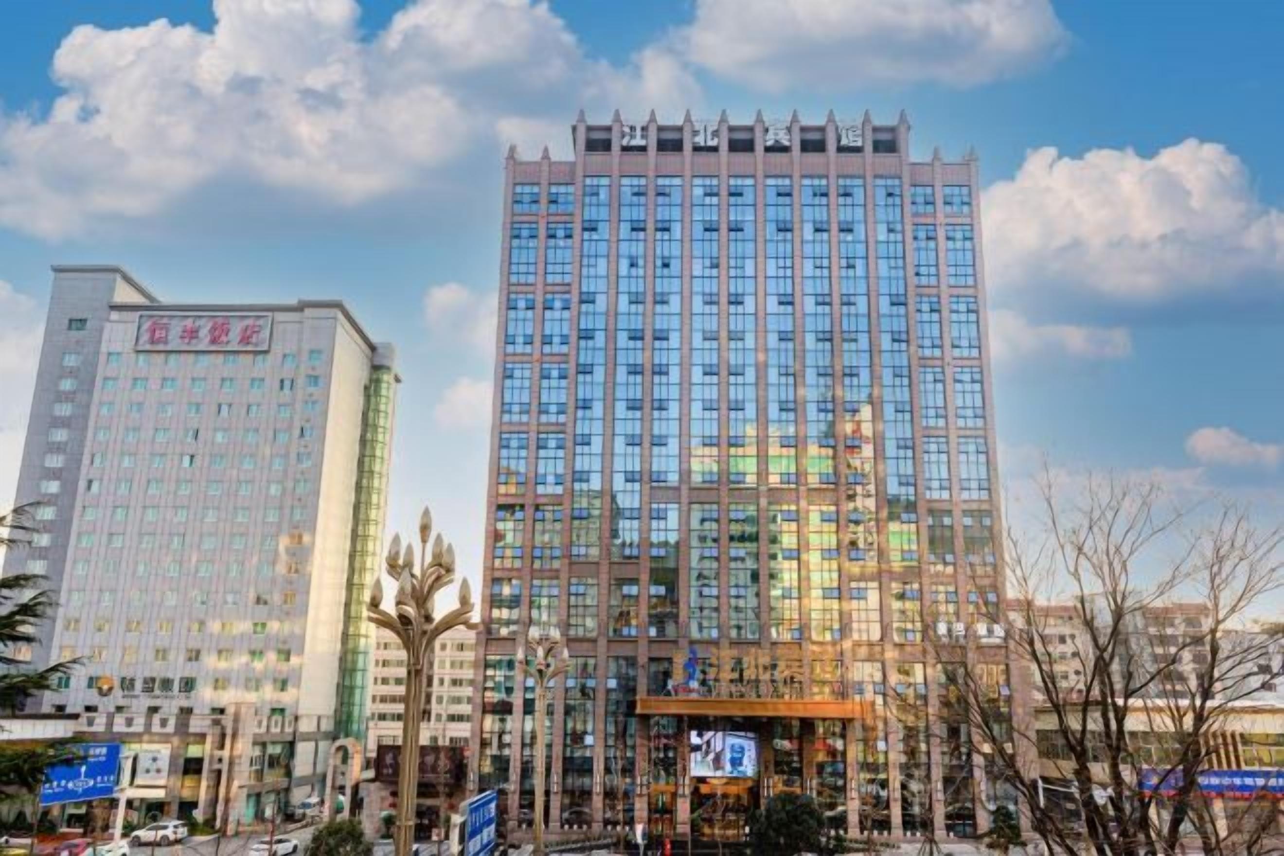 A multi-story building with a modern architectural design, featuring a prominent glass facade and a series of vertical lines at the top.
