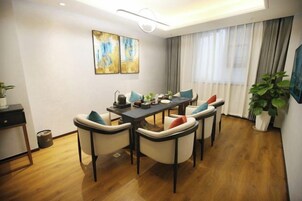 Un comedor con mesa de madera, sillas y una obra de arte en la pared.