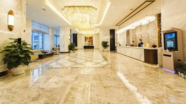 A spacious lobby with a marble floor, a reception desk, and a large chandelier. - Bazhong Jiangbei Hotel (Bazhong)