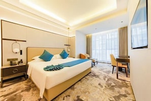 Une chambre d’hôtel avec un grand lit, un bureau et une chaise.