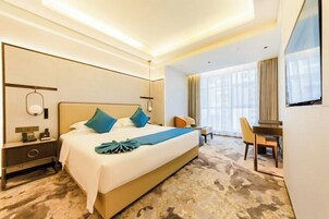Una habitación de hotel con una cama grande, un escritorio y una silla.