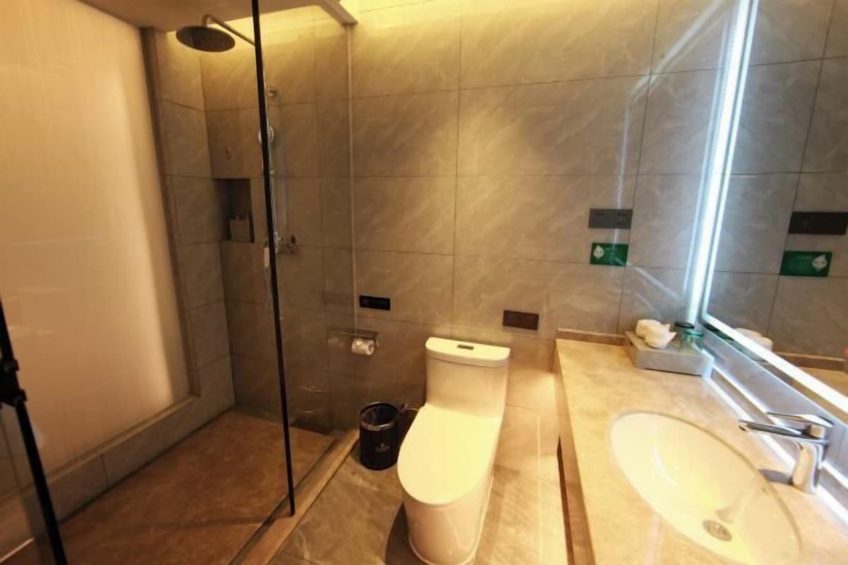 Un baño moderno con cabina de ducha de vidrio, inodoro y lavamanos.