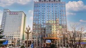Two high-rise buildings with reflective glass facades, one with a sign in a foreign language, and a decorative sculpture in the foreground. - Bazhong Jiangbei Hotel (Bazhong)