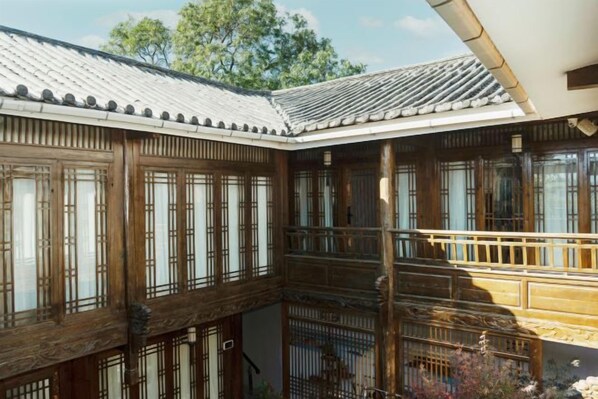 A traditional Japanese-style building with multiple wooden floors, large windows, and a tiled roof.