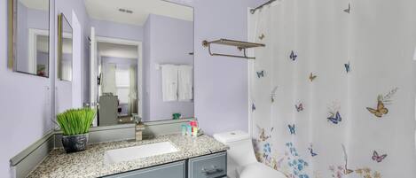 Une salle de bain équipée d’un meuble-lavabo, d’un lavabo, d’un miroir et de toilettes.