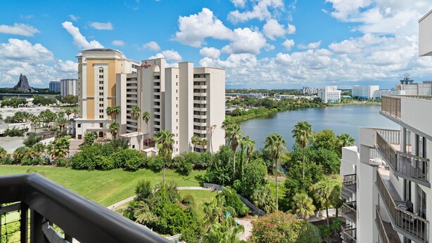 Un hotel con varios edificios altos, un río y palmeras.
