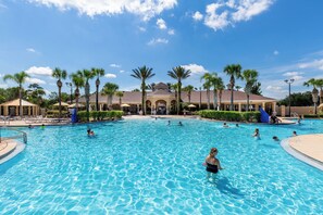 A large outdoor swimming pool with multiple lanes, surrounded by palm trees and lounge chairs. - 2533 Renshaw Street (Kissimmee)