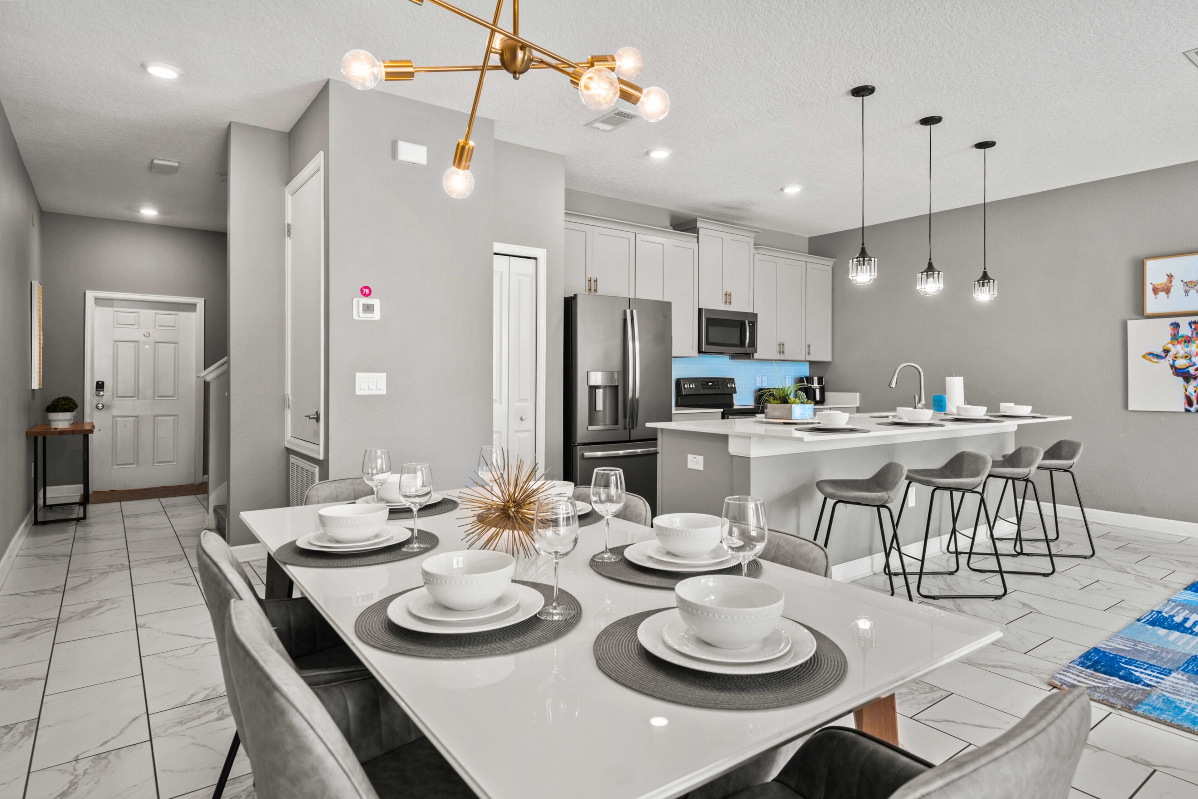 A modern kitchen with a central island, white cabinetry, and stainless steel appliances.