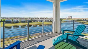 A balcony with a view of a river, a row of houses, and a distant building. - 3141 Paradox Circle #406 (Kissimmee)
