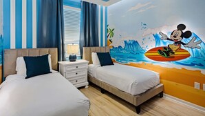 A hotel room with two beds, a nightstand, and a mural of Mickey Mouse surfing. - 3141 Paradox Circle #406 (Kissimmee)