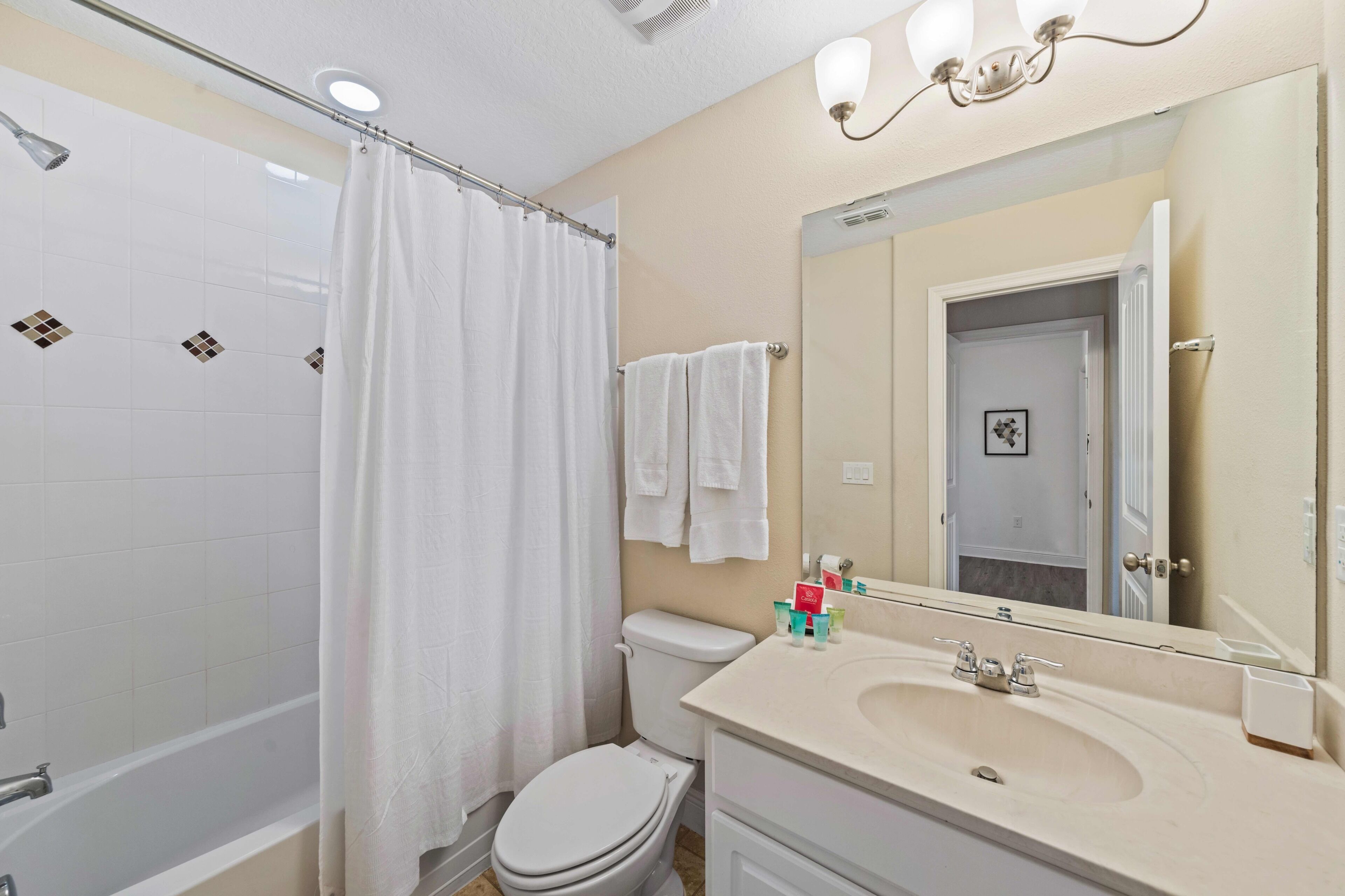 A bathroom with a bathtub, toilet, and sink.