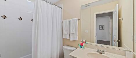 A bathroom with a bathtub, toilet, and sink.