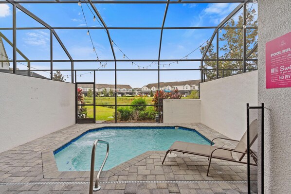An indoor swimming pool with a clear view of the surrounding neighborhood. - 409 Captiva Drive (Davenport)