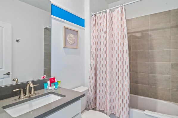 A bathroom with a sink, mirror, and shower curtain. - 520 Sticks Street (Kissimmee)