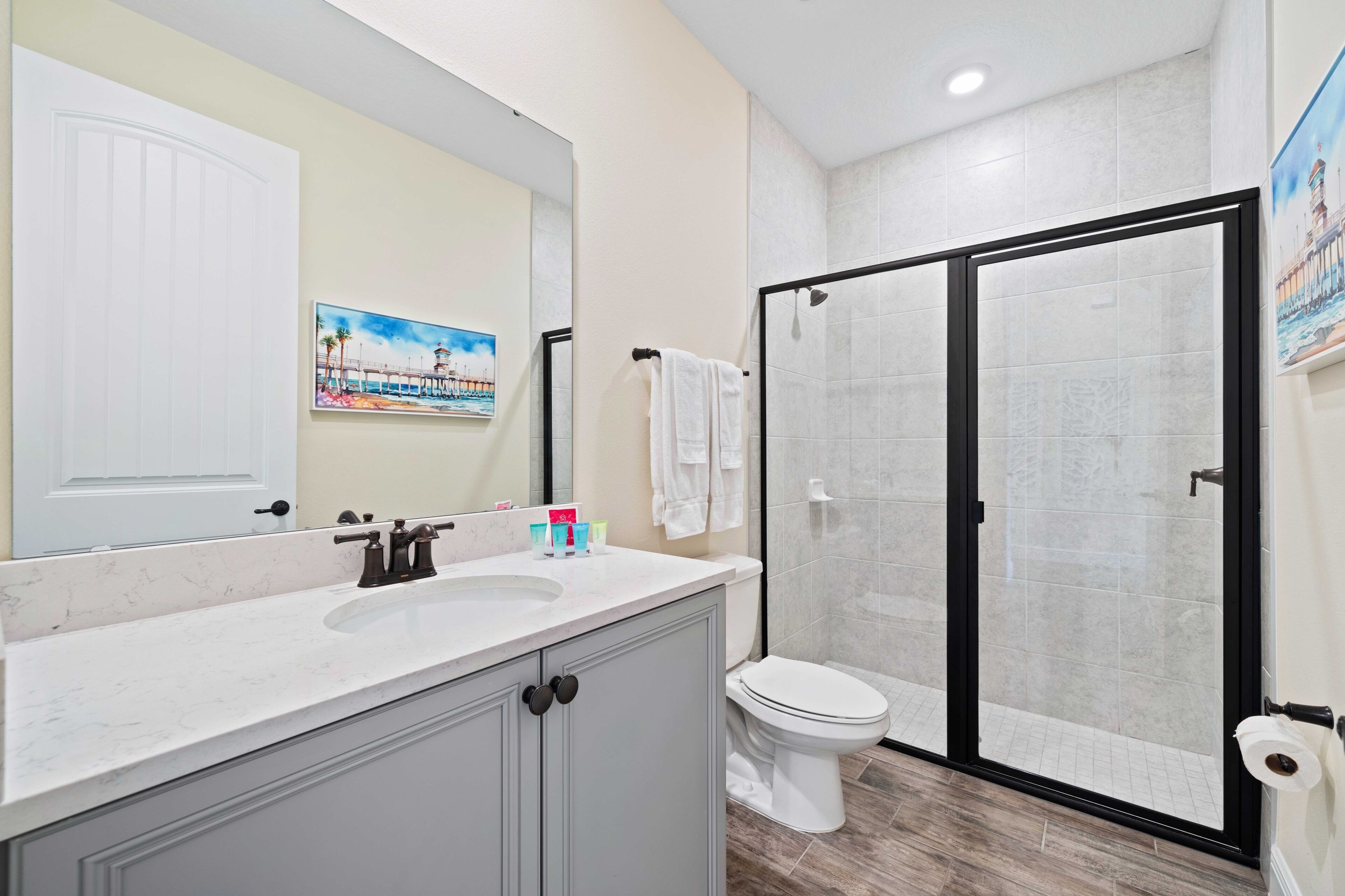 A bathroom with a white sink, a toilet, and a glass-enclosed shower.