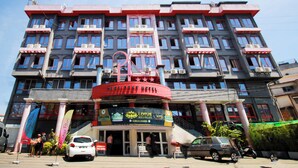A multi-story hotel with a prominent red and white facade, balconies, and a sign for 'Lotus Meubles'. - Big Bang Hotel Antananarivo (Antananarivo)