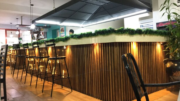 A bar area with a counter, stools, and a ceiling light fixture. - Big Bang Hotel Antananarivo (Antananarivo)