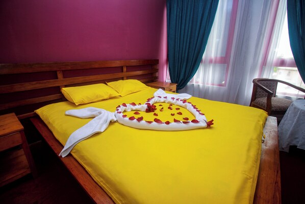 Una cama con una colcha amarilla, un cabecero de madera y una almohada blanca.