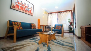 A living room with a sofa, two armchairs, a coffee table, and a painting on the wall. - Big Bang Hotel Antananarivo (Antananarivo)