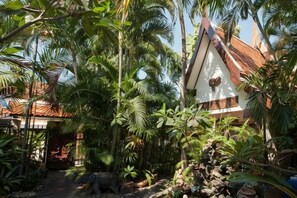 A traditional building with a sloped roof, surrounded by dense tropical vegetation. - LePrive Resort (Pattaya)