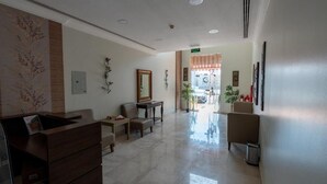 Hall dell'hotel con reception, area salotto e vista sull'ingresso.