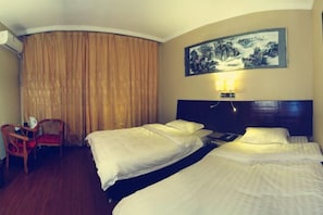 A hotel room with two beds, a chair, a painting on the wall, and an air conditioning unit.