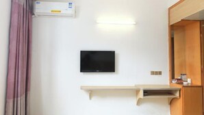 A room with a mounted TV, a wall-mounted air conditioner, and a wooden cabinet. - ChunHui Inn Hotel (Wuyishan)