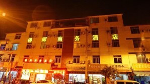 A multi-story building with illuminated signage indicating it is a hotel. - ChunHui Inn Hotel (Wuyishan)