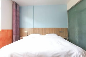 Un dormitori amb un llit, una tauleta de nit i un armari.