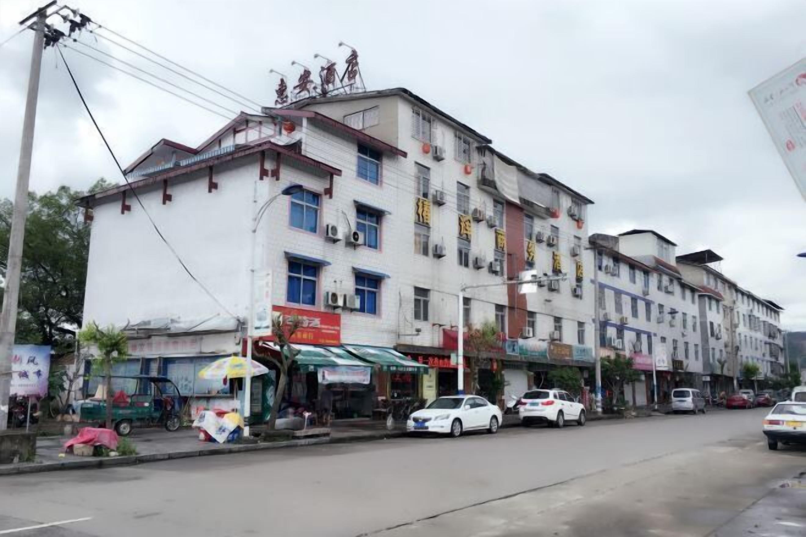 A multi-story building with various shops on the ground floor.