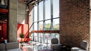 A modern interior with a brick wall, large windows, and contemporary furniture.